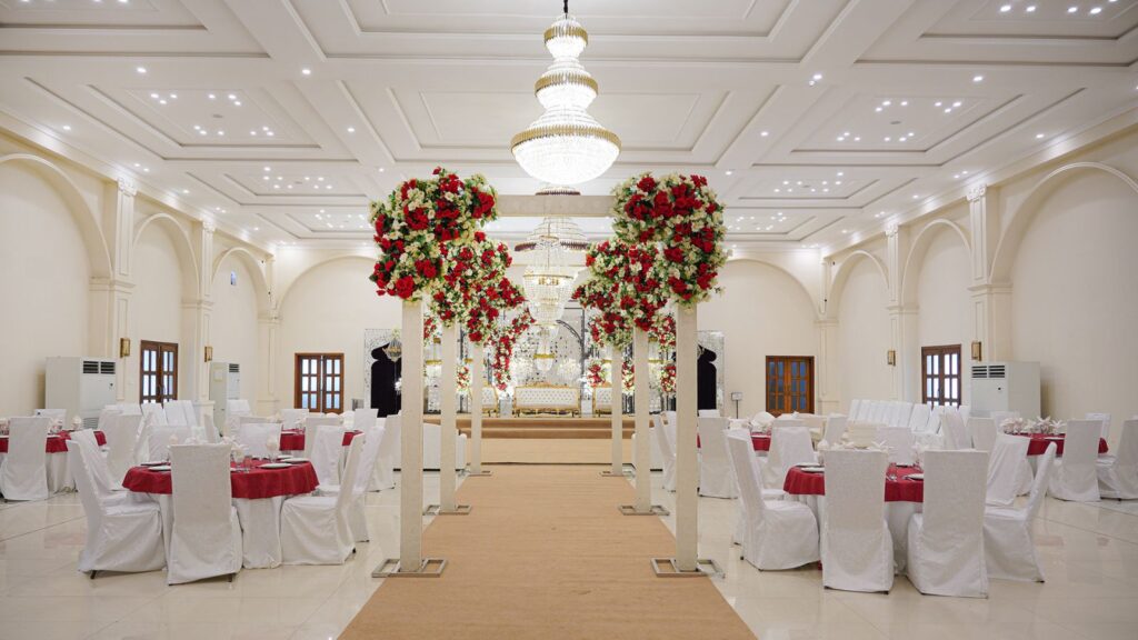 Crystal Hall set for a wedding, with red and white floral arches and a crystal chandelier