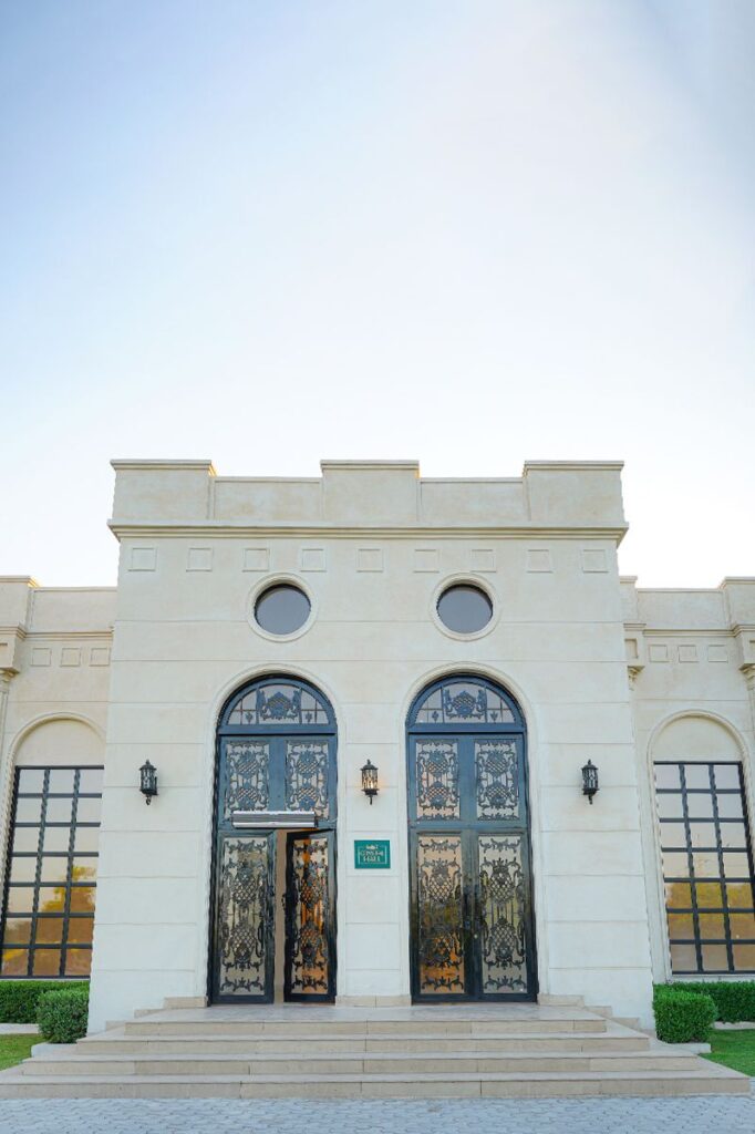 The cream stone entrance of Crystal Hall, with arched iron doors and wide steps