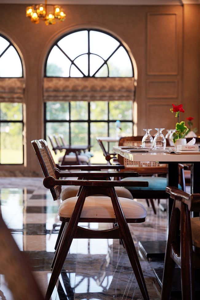 Dining tables set beneath arched windows